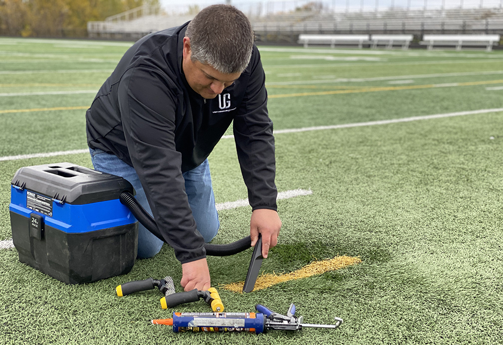 Tony Gustafson of Riverbend Sports Turf / Uncommon Ground doing some work on artificial turf